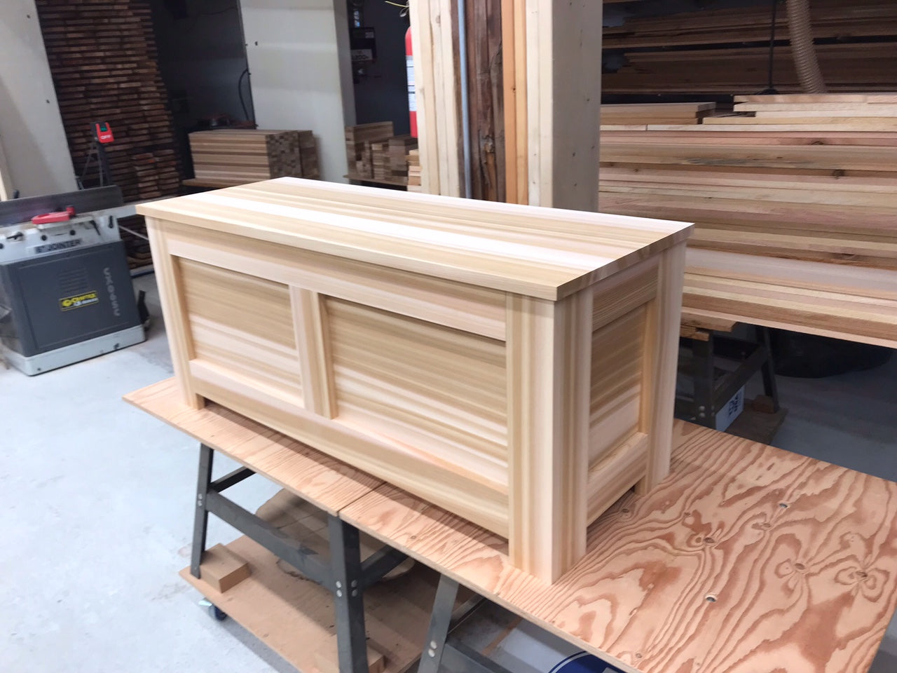 Side angle view of a Western Red Cedar blanket chest showing the paneled construction and solid cedar lid