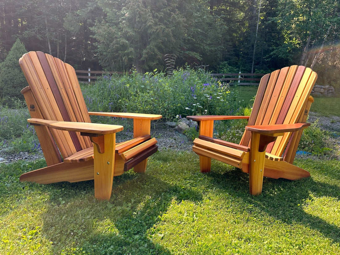 Two Western Red Cedar Adirondack chairs facing each other on a lawn in the evening sun