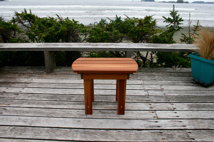 Front view of the matching side table on a weathered deck overlooking the beach