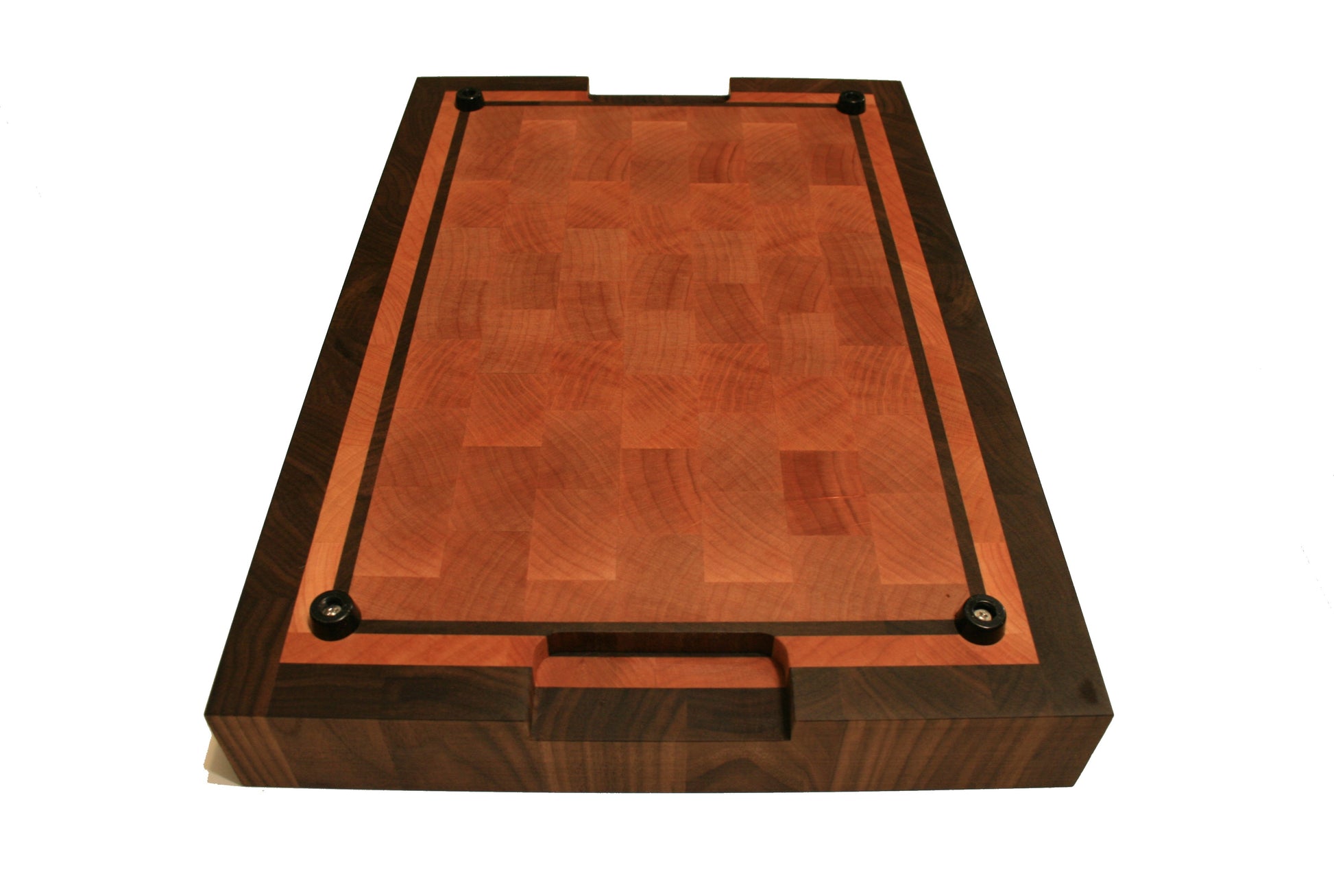 Underside view of the bordered cutting board showing rubber feet and handholds at each end