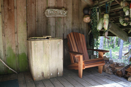 Western Red Cedar Adirondack chair on a rustic wooden deck with fishing floats and weathered wood