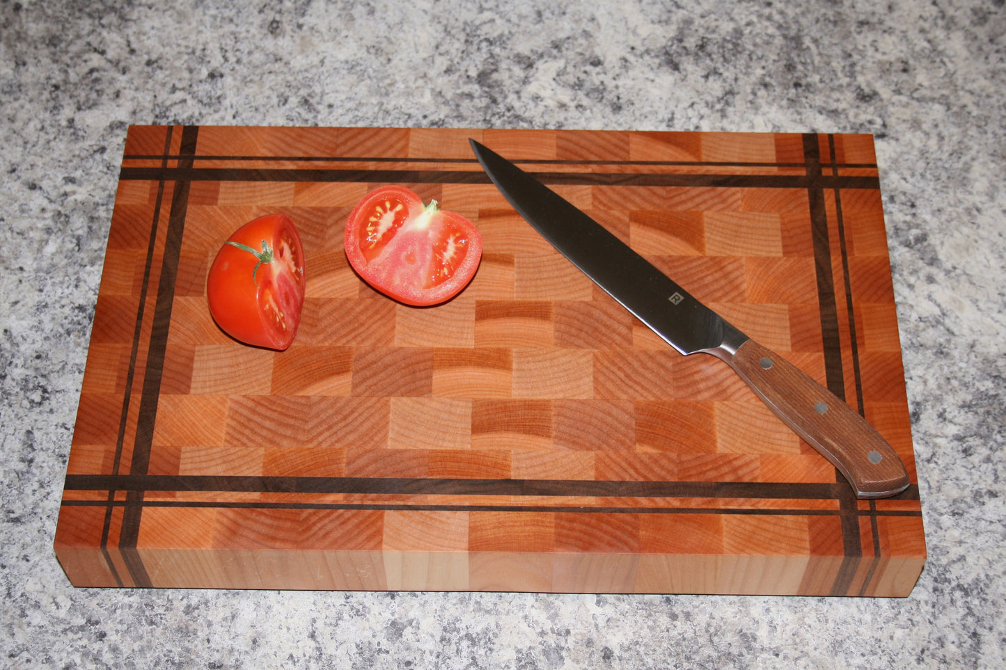 Striped end-grain cutting board made from Eastern Maple and Black Walnut with knife and tomatoes