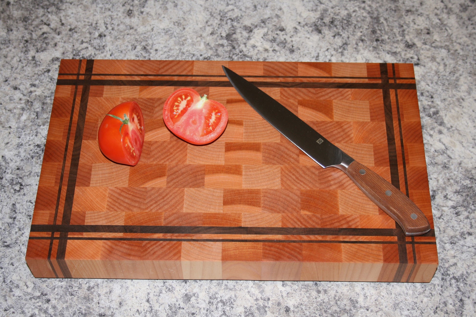 Striped end-grain cutting board made from Eastern Maple and Black Walnut with knife and tomatoes