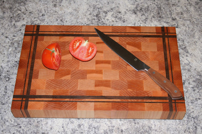 Striped end-grain cutting board made from Eastern Maple and Black Walnut with knife and tomatoes