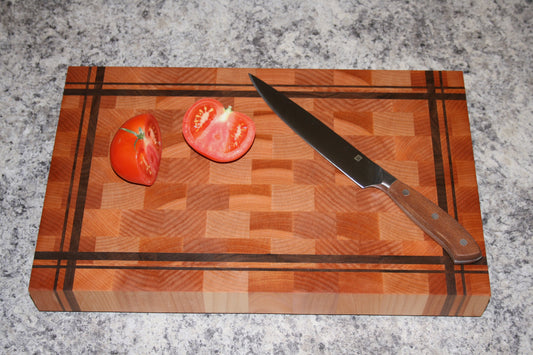 Striped end-grain cutting board made from Eastern Maple and Black Walnut with knife and tomatoes