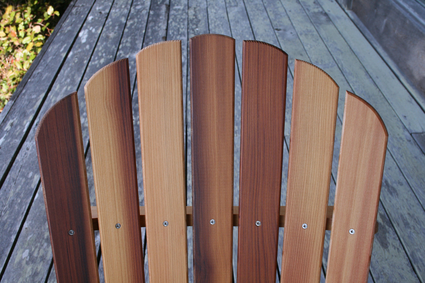 Close-up of the back slats showing straight vertical grain, stainless-steel fasteners and natural cedar tones