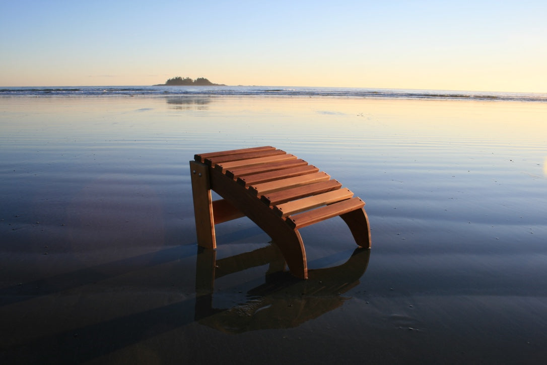Separate curved footrest shown on the beach, illustrating how it can be positioned independently