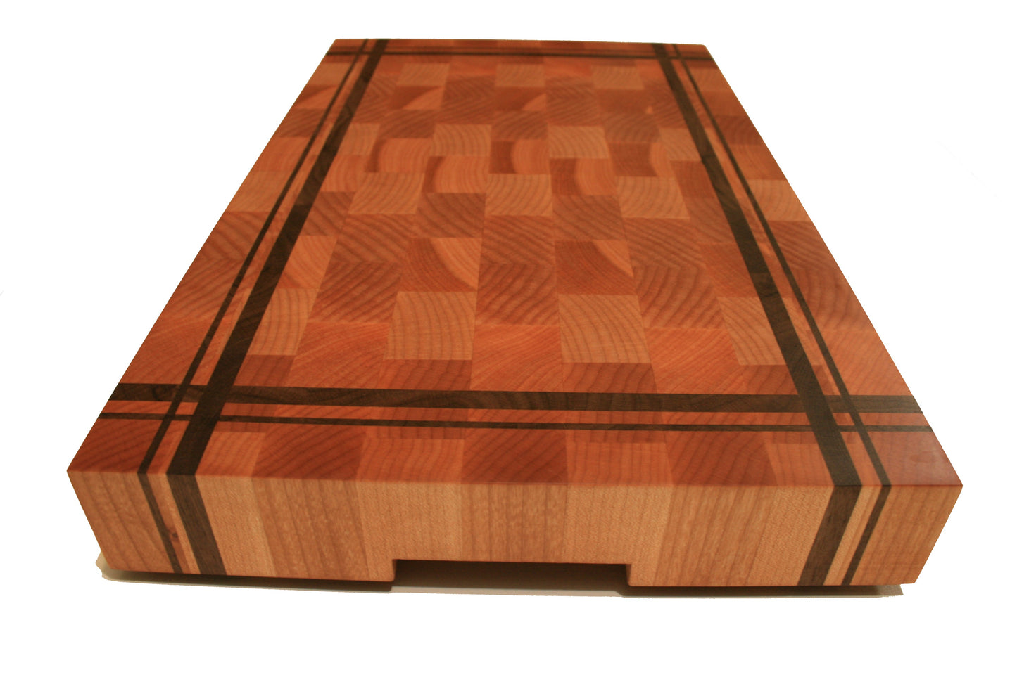End view of the striped butcher block cutting board showing the recessed handhold