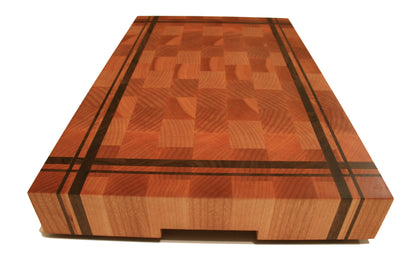 End view of the striped butcher block cutting board showing the recessed handhold