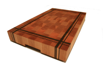 Angled view of a striped end-grain cutting board showing its thickness and recessed handhold