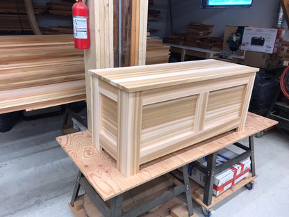 Angled view of a Western Red Cedar blanket chest showing the front, side and hinged lid